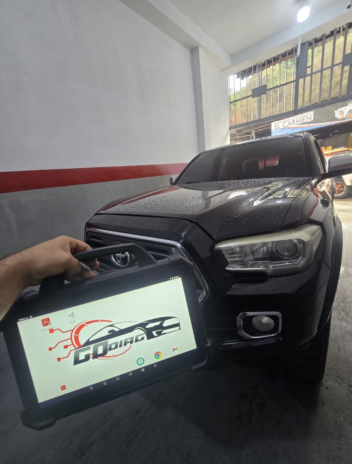 Diagnóstico electrónico con equipamiento GoDiag junto a un vehículo Toyota